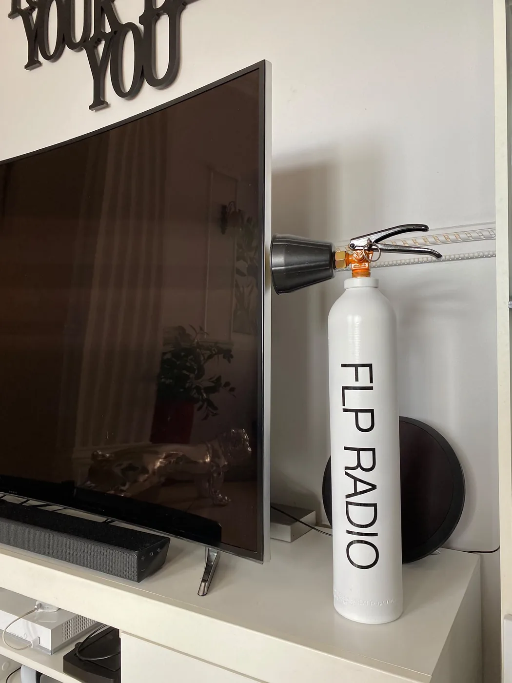 Extincteur blanc personnalisé au marquage FLP Radio aux couleurs de l'entreprise — Art'cade Design Nice