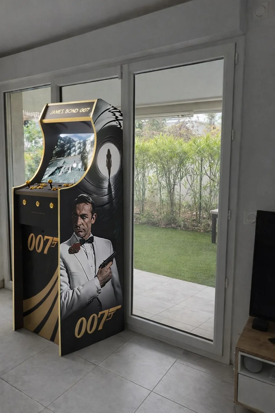 Borne arcade James Bond terminée, posée près d'une baie vitrée — Art'cade Design Nice