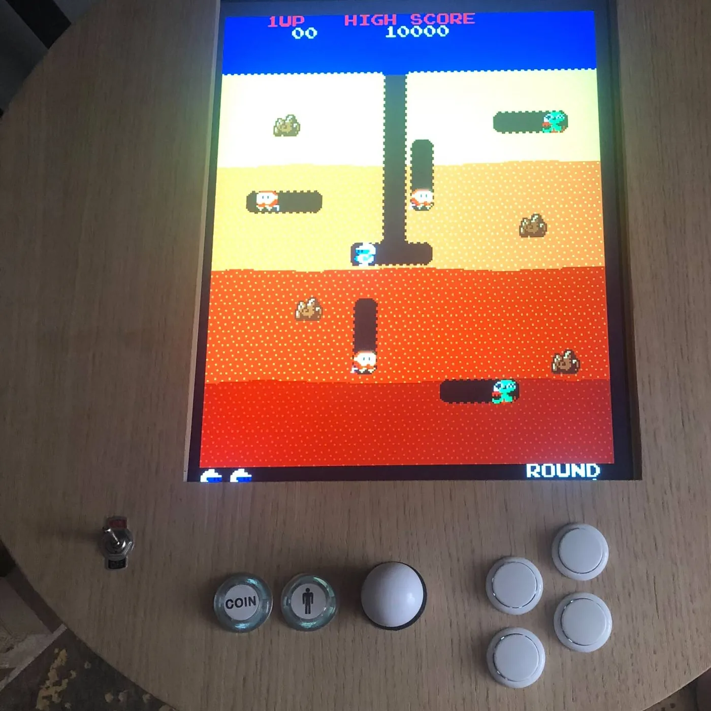 Écran de jeu Dig Dug et panneau de commande d'une table cocktail arcade ronde en bois — Art'cade Design Nice